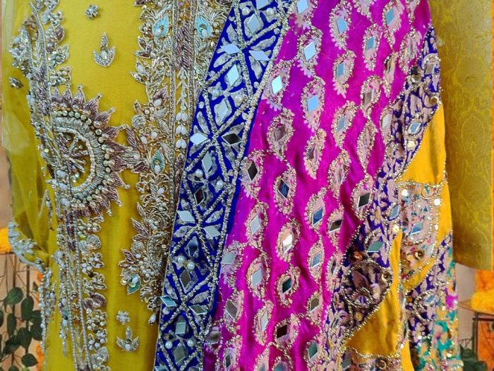 A detailed view of the Amber Splendor dupatta, showcasing the intricate mirror work and heavy hand embellishments on rich Indian silk, adding a touch of grandeur to the ensemble.