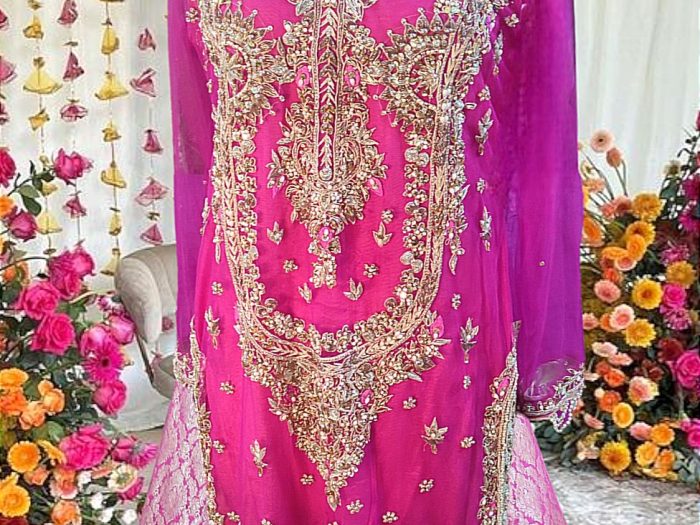 Fuchsia Fame – A captivating two-piece wedding couture ensemble featuring a richly hand-embellished pink shirt paired with a luxurious pure atlas jamawar sharara. The intricate craftsmanship and regal design exude elegance and grandeur.